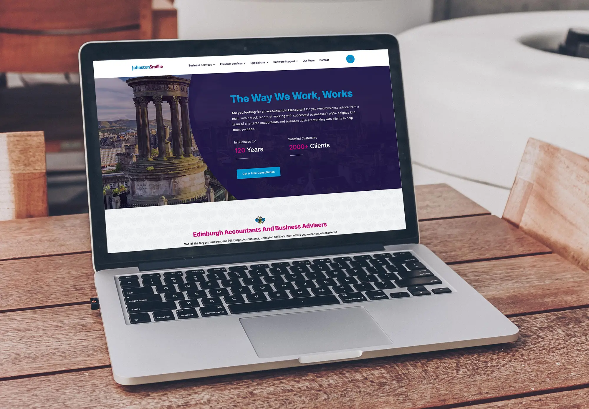 Laptop on an outdoor table displaying the Johnston Smillie Chartered Accountants website homepage